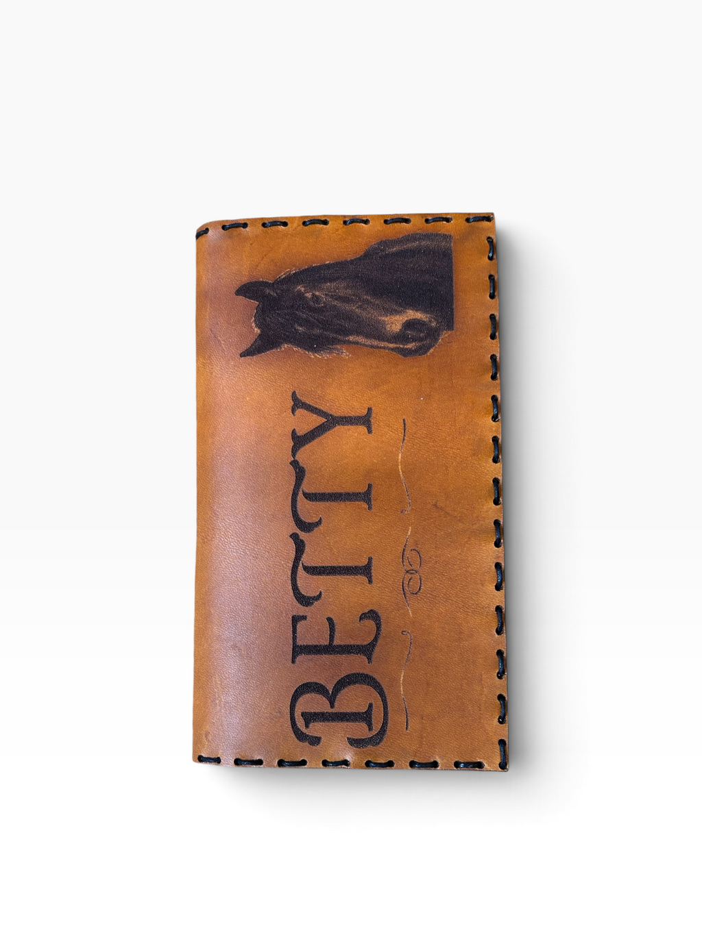 Personalized leather checkbook cover front view with BETTY engraving and horse portrait, white background
