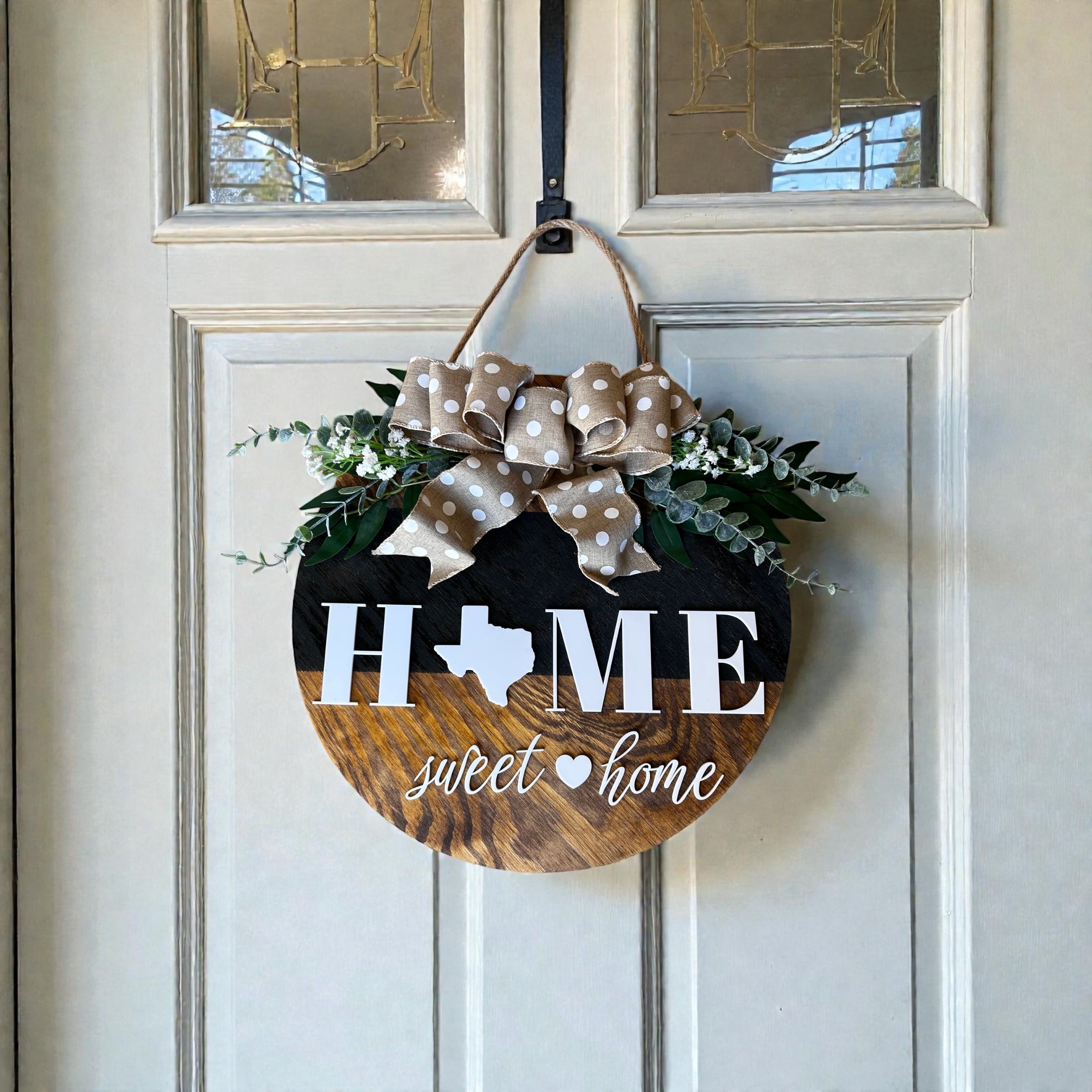 Texas Home Sweet Home round wood door hanger with polka-dot burlap bow and faux greenery on a white front door